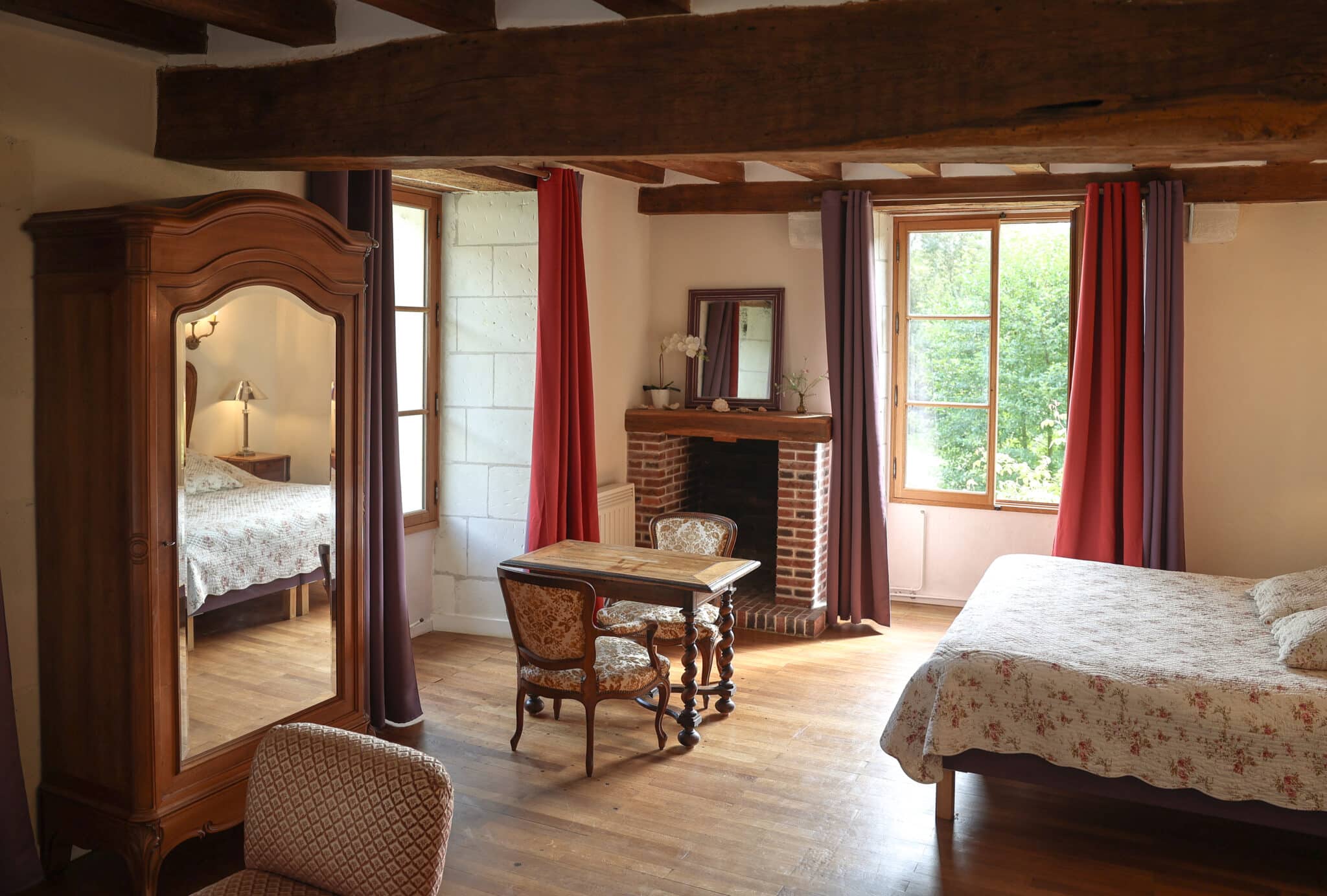 Chambre Cardinale du Château de la Corroirie – suite lumineuse avec baignoire et vue sur l’église